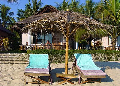 Bungalows under palm trees at the Silver Beach Hotel on Ngapali sandy beach