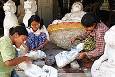 Burmese girls working on marble Buddhas