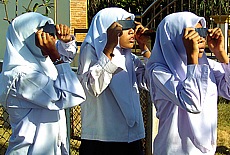 Muslim young girls on Ko Lanta watch partial solar eclipse