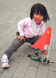 Child with military toys on Tiananmen Square