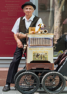 Barrel organ musician plays near Rmer