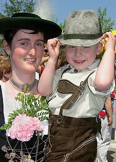 Bavarian young guy and dirndl in leather trousers at maypole festival