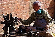 Old Nepalese woman with spinning wheel in Patan