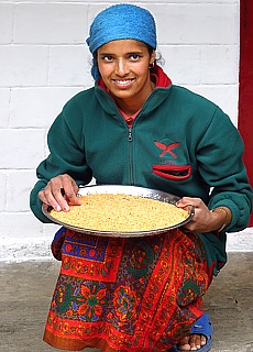 Young Nepali woman sorts millet seed