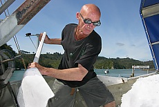 Fisherman shovels ice in his boat