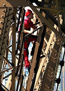 Parisian firemen climb onto the steel girders of Eiffel Tower